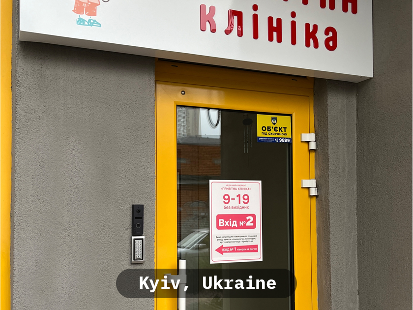 Professional Slinex access control monitor at an office reception desk.